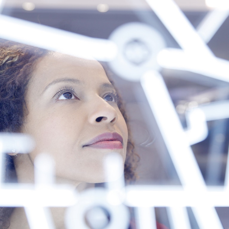 Business woman looking at a futuristic digitally generated display.