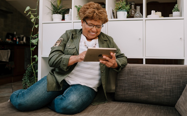 Woman uses tablet device at home