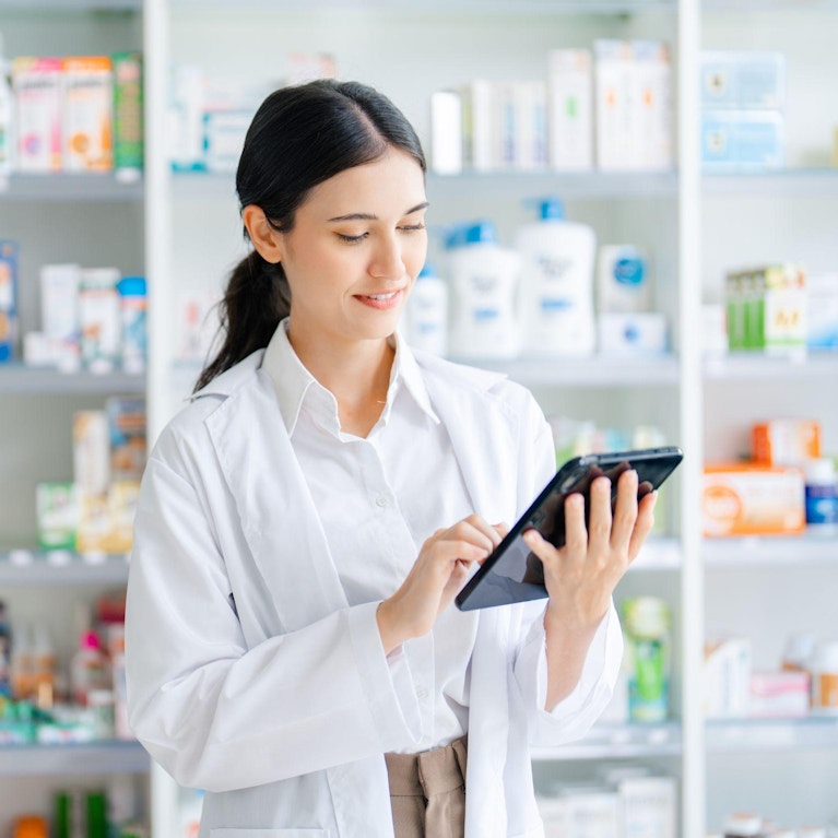 Pharmacist using handheld device in pharmacy