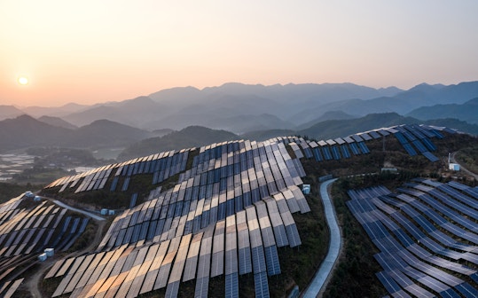 Aerial view of the solar power plant on the top of the mountain at sunset