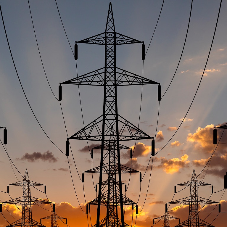 High voltage towers at sunset background. Power lines against the sky.