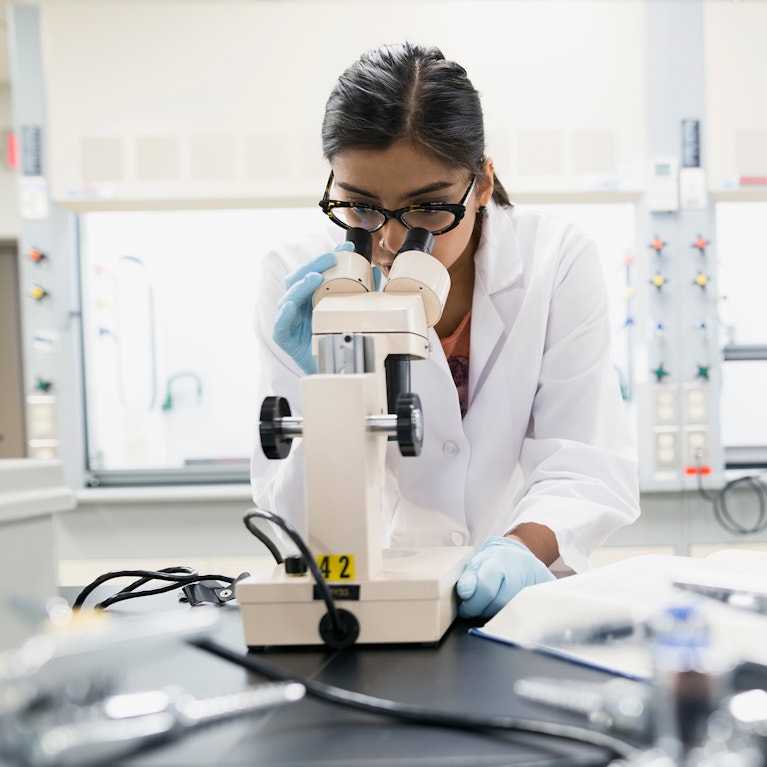 Scientist using microscope in laboratory