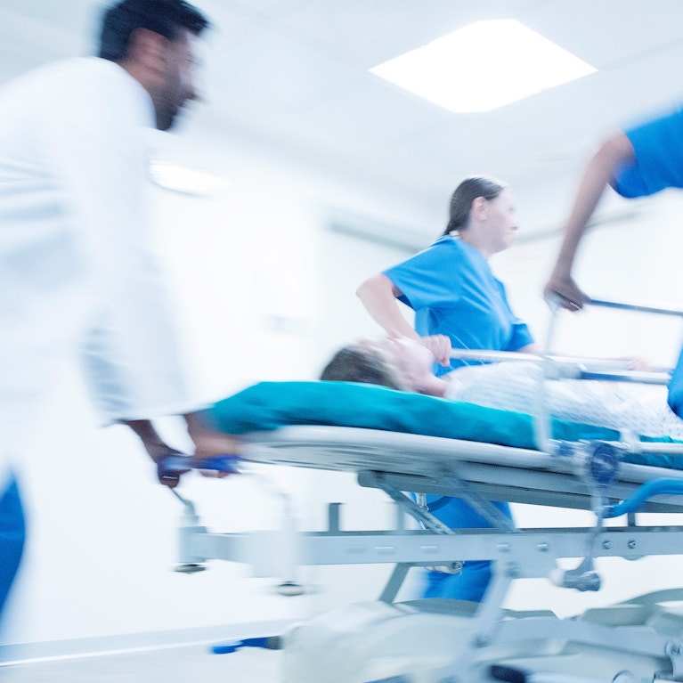 Hospital emergency, medical staff pushing patient on gurney