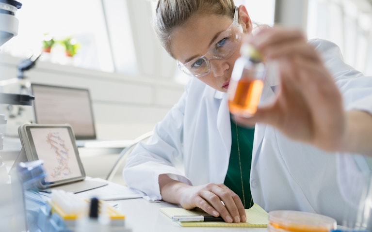 Scientist examining liquid in jar