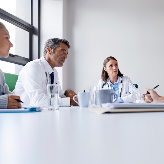 Surgeons discussing at table in board room