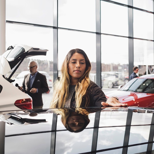Woman assessing a vehicle in car dealership