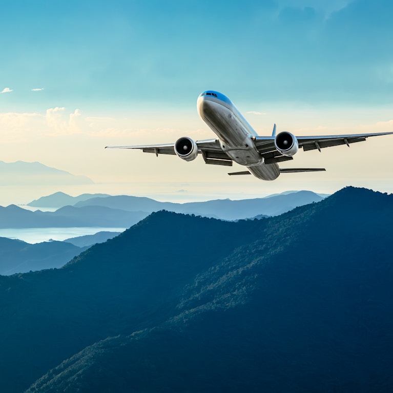 Plane takes off over green hillside