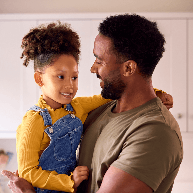 Parent smiling and holding young child